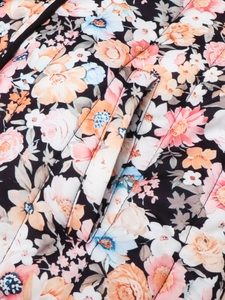 Detail of floral quilted jacket showing colorful prints and fine stitching on pocket