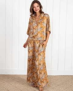 Detail of tiger print pajama set featuring yellow high-waisted wide-leg trousers and shirt