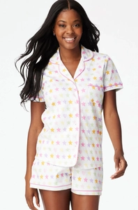 Detail of summer pajama set featuring colorful star and heart prints with pink piping trim