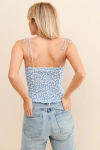 Détail du haut à fleurs bleues montrant le dos smocké élastique et les fines bretelles