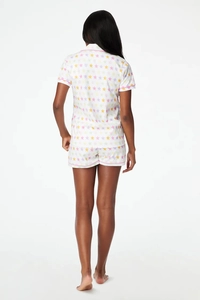 Rear view of women short sleeve pajama set with colorful star print and pink piping trim