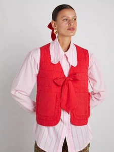 Red quilted vest for women featuring large bow tie closure and elegant ruffled pockets