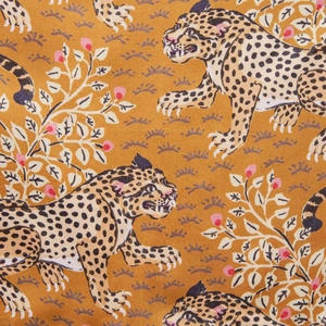 Detail shot of vintage leopard and berry plant prints on high-quality yellow fabric