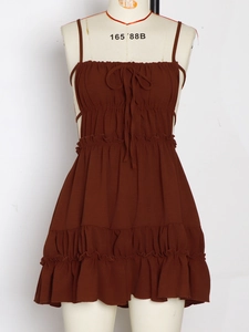 Detail of coffee brown mini dress featuring ruched bodice and adjustable bow tie