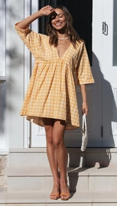 Détail de la robe à carreaux jaune et blanc avec col en V et tissu coton-lin doux