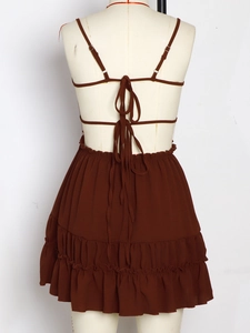 Detail of a brown backless tiered dress showing crisscross ties and ruffled layers