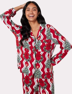 Détail de pyjamas de Noël avec imprimés de sapins et couronnes sur tissu doux à manches