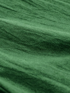 Macro shot of green elastic fabric with detailed woven texture and vertical pleat texture