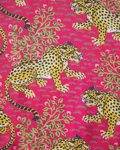 Detail of vibrant fabric with repeating leopard, leaf, and pink floral patterns