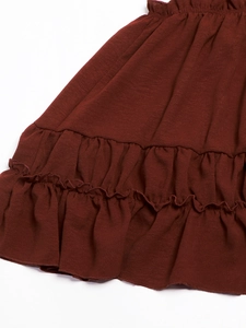 Detailed view of the layered ruffles and textured knit fabric on a burgundy sundress