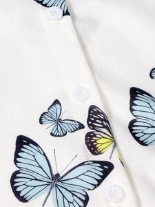Close-up of white shirt fabric with blue butterfly print and four-hole buttons