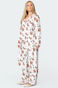 Détail d'un ensemble de pyjama de Noël avec motifs de Père Noël et rennes sur blanc