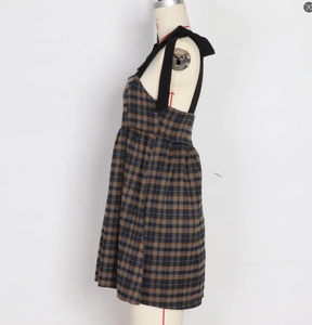Détail de robe sans manches à carreaux avec bretelles à nœuds noirs et coupe trapèze évasée