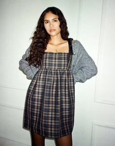 Détail d'une robe à carreaux rétro avec taille froncée et cardigan en maille grise