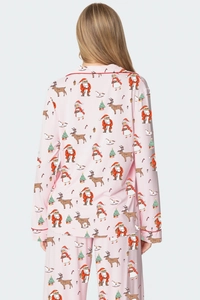 Détail de pyjama de Noël avec motifs festifs et liseré rouge sur tissu rose doux