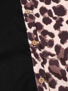 Detail of color-block shirt with leopard print fabric and natural wooden buttons