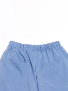Détail de la taille haute élastique et des deux poches arrière sur ce short bleu clair