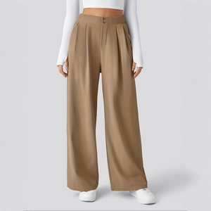 Detail of high-waisted wide leg trousers featuring double button closure and pleated front