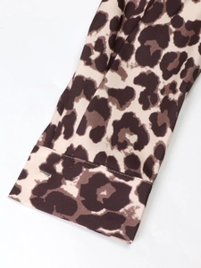 Detailed view of leopard print long sleeve shirt cuff with fine stitching and buttonhole