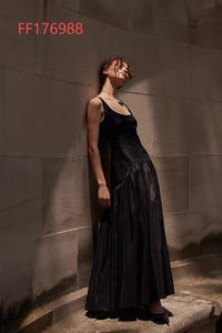 Détail d'une robe longue noire chic à taille basse avec une jupe plissée et fini soyeux