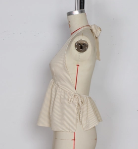 Detail view of beige striped halter top with open back design and adjustable side ties