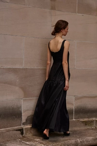 Détail d'une robe longue en satin noir avec larges bretelles et dos carré de coupe évasée