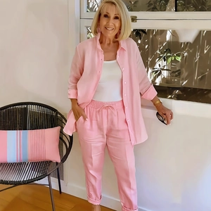 Detail view of pink cotton linen suit with button-up shirt and drawstring trousers