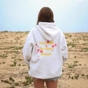 Detail view of female oversized hoodie featuring floral embroidery and back slogan print