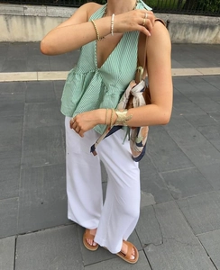 Detail view of green striped V-neck halter top with white high-waist wide-leg pants set