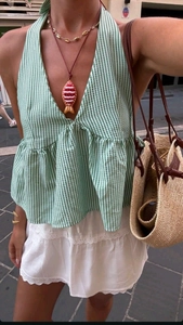 Detail of green plaid halter top with ruffles and white lace skirt for summer vacation
