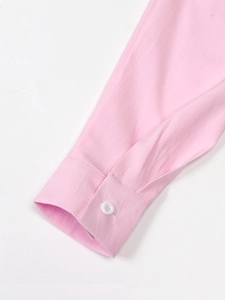 Detailed close-up of pink linen suit sleeve cuff with fine texture and white button