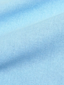 Macro detail of breathable light blue cotton linen fabric showing natural weave texture