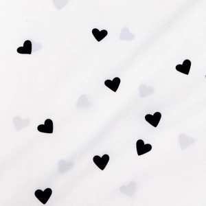 Detailed view of white fabric featuring small black heart patterns for summer shirts