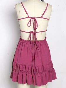 Detail of mauve backless dress featuring criss-cross straps and tiered ruffle skirt