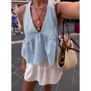 Detail of blue striped halter neck top with ruffled hem and layered summer jewelry