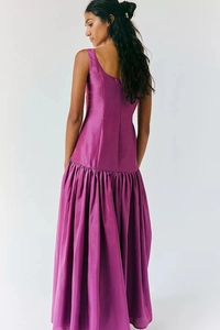 Détail d'une robe maxi magenta à taille basse avec décolleté en U et jupe volumineuse