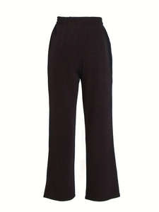 Detail view of women's black high-waisted wide-leg trousers with elastic waistband