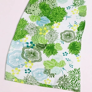 Close-up of floral print fabric with green chrysanthemums and detailed hem stitching