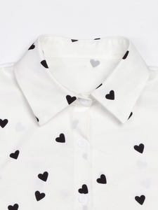 Detailed view of classic collar and black heart print on white button-down shirt