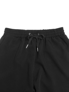Detailed macro view of the elastic drawstring waistband with premium metal cord ends
