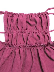 Macro shot of smocked pink dress fabric with ruffled edges and thin strap details