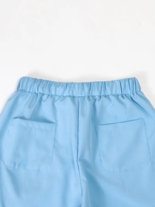 Detail of light blue linen trousers showing elastic waistband and two rear patch pockets