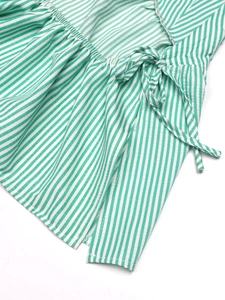 Detailed view of green and white striped top with ruffled edges and drawstring bow detail