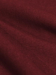 Close-up of dark red cotton linen fabric showing detailed woven texture and soft drape