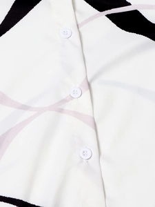 Macro shot of white button-down shirt with black and pink abstract prints and buttons