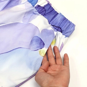Detailansicht des elastischen Bundes und der Seitentasche der lila geblümten Hose