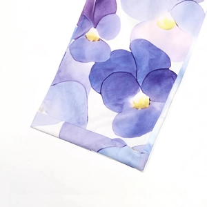 Detailansicht von glattem Stoff mit lila Stiefmütterchen-Print und hochwertigen Nähten