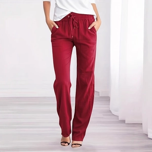Detail of loose fit cotton linen trousers with adjustable drawstring waist in dark red
