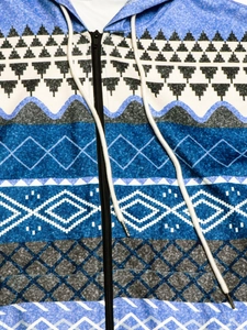 Detail of ethnic geometric print on zip-up hoodie with white drawstring and metal zipper
