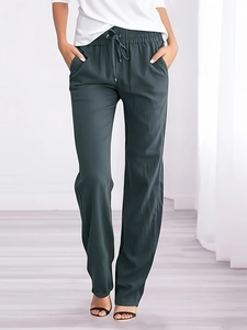 Detail view of dark green casual pants with elastic drawstring waist and side pockets